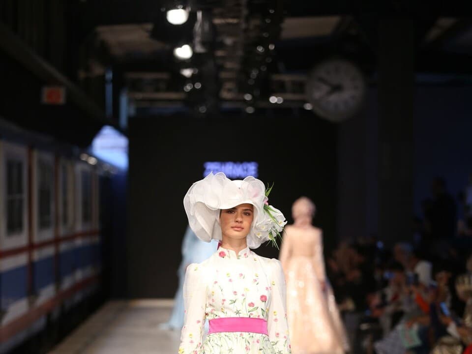 A model walking a runway in a show, representing the fashion show format